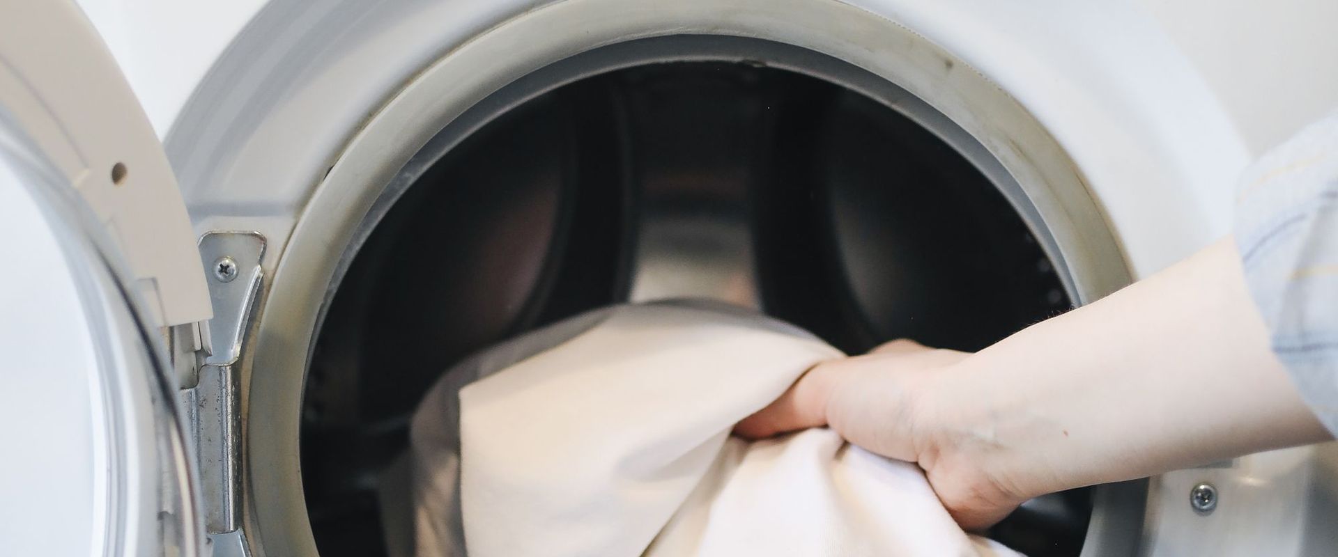 Hand loading laundry into a front-load washing machine