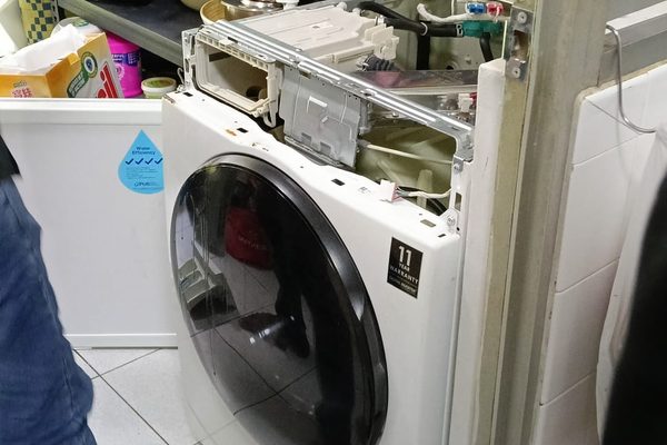 Samsung front loader opened up for repair in an HDB kitchen