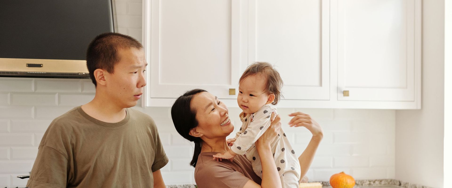 Young family together in a bright kitchen at home