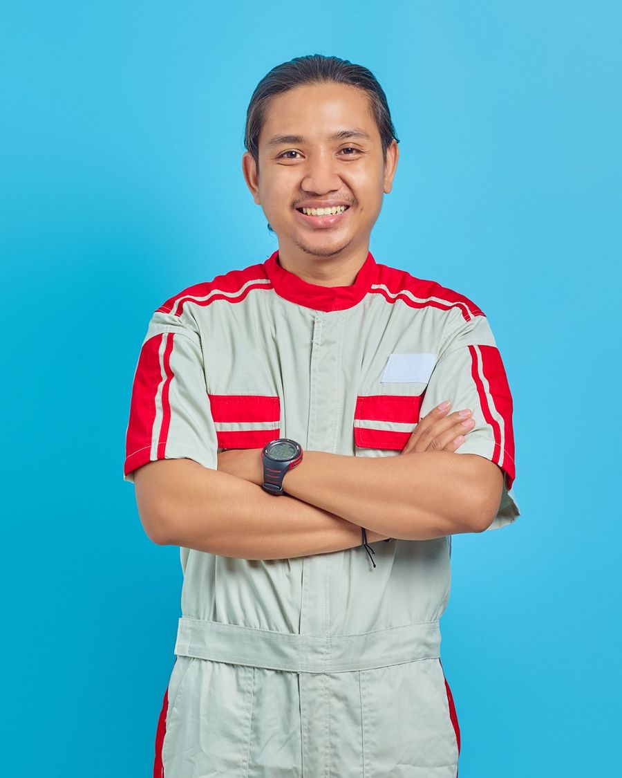 Smiling technician in uniform with arms crossed